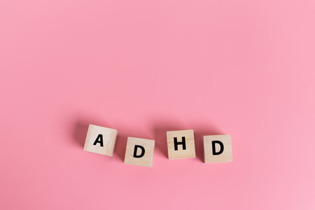 Wood cube block Abbreviation of ADHD on pink table. Attention Deficit Hyperactivity Disorder. ADHD concept.の写真素材
