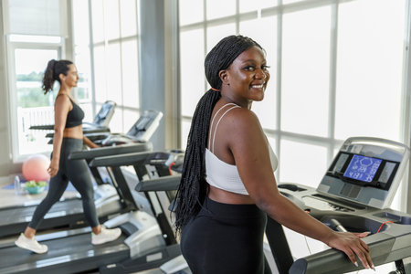 Healthy strong female African American plus-size sportswear exercise running treadmill fitness in gym health club. sportswoman slim motivation run fitness calories burn.の写真素材