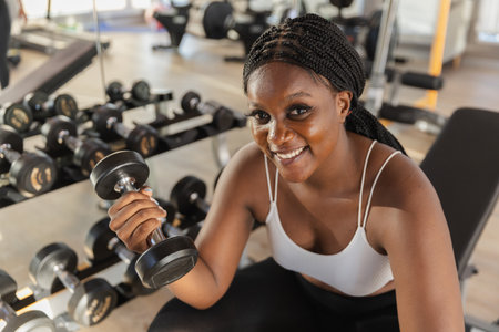 Healthy strong female African American plus-size holding dumbbells lifts weights exercise in gym. sport training weights fitness, Exercise to lose weight, take care of health.の写真素材