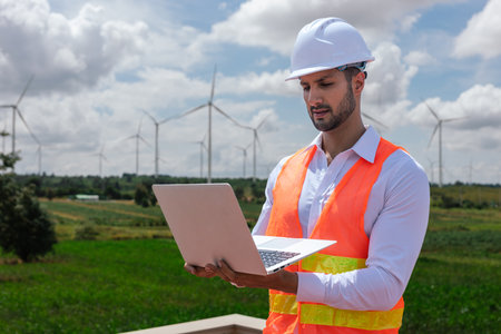 Engineer wearing safety uniform holding laptop discussed plan about renewable energy at station energy power wind. technology protect environment reduce global warming problems.の写真素材