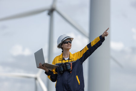 Female engineer wind turbine worker survey operational planning windmill clean renewable energy...