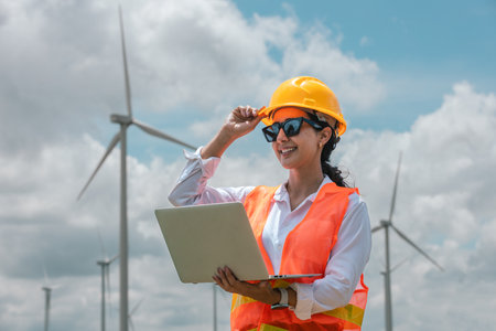 Renewable energy systems concept, engineer female using laptop working wind turbine for alternative energy, Technology protect environment reduce global warming problems.の写真素材
