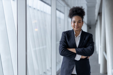 Successful young businesswoman african american black suit crossed arms smiling looking at camera at...