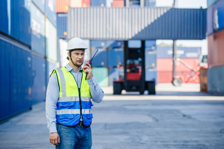 Foreman using radio walkie talkie control loading containers box in cargo for import export,...