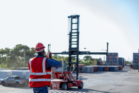 Foreman using radio communication control loading containers in shipping yard, for logistics and...