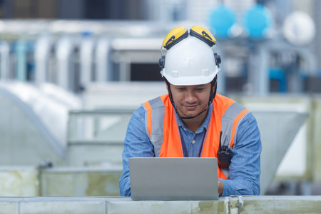 Man engineer holding laptop working at rooftop building construction. Male technician worker working...