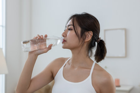 Asian young female sporty drinking water from water bottle while exercising. stay hydrated per day....
