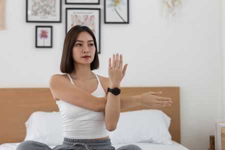 Asian young woman morning exercises after waking up on bed, Stretch feet forward. Relax and stretch...
