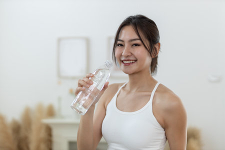 Asian young female sporty drinking water from water bottle while exercising. stay hydrated per day. Healthy fit woman fresh wellness. Drinking water makes you feel good.の写真素材