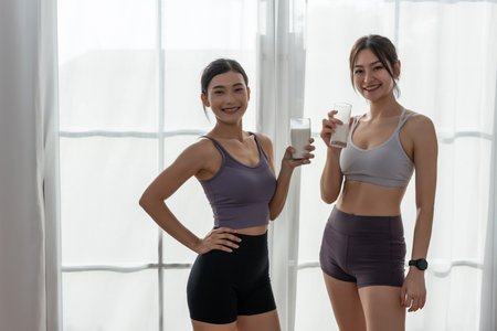 Asian beautiful attractive female sportswear holding glass drinking milk food nutrition healthy with active exercise. contains good fats, which give energy to body. Milk high calcium.の写真素材