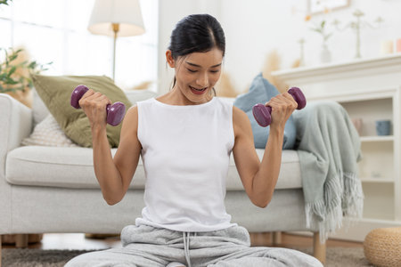 young female working out shoulder holding up dumbbell active strong exercising arm  training muscle fitness weight.の写真素材