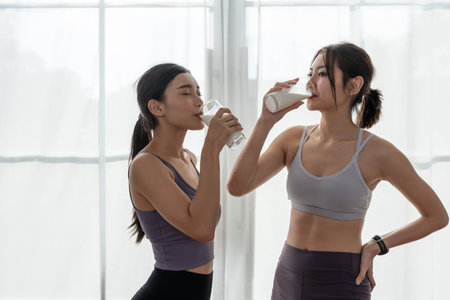 Asian beautiful attractive female sportswear holding glass drinking milk food nutrition healthy with active exercise. contains good fats, which give energy to body. Milk high calcium.の写真素材