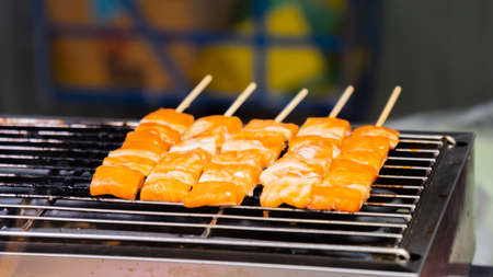 Grilled salmon skewers are placed on the grill.の写真素材
