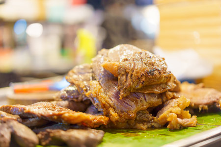 Roast beef resting on banana leaves and blurred background.の写真素材