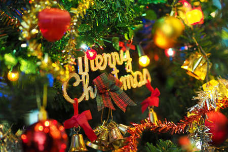 Christmas tree decorations closeup with lights, bells and gift boxesの写真素材