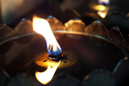 Flickering oil lamp flame closeup at the templeの写真素材