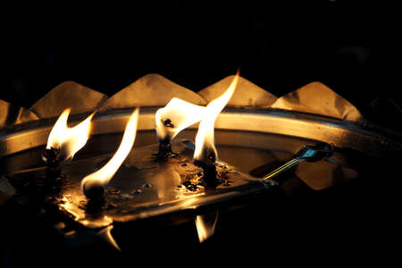 Flickering oil lamp flame closeup at the templeの写真素材