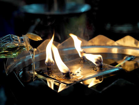 Oil pouring into lamp closeup at the templeの写真素材