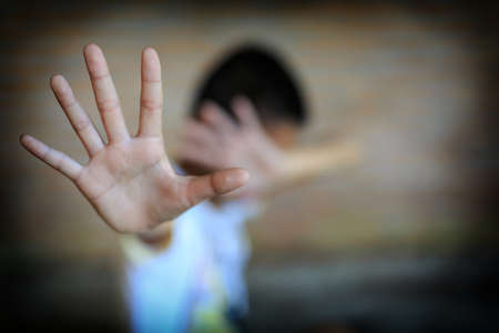 Stop abusing boy Children violence. boy, lad with her hand extended signaling to Stop,child bondage in angle of abandoned building image blur and pain, afraid, restricted, trapped, call for help, struggle, terrified, violence, slave, Human Rights Day concの写真素材