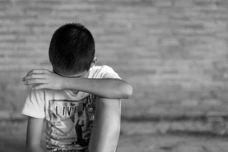 a Boy crying,fear in angle of abandoned building image blur Children violence. boy, lad with her hand extended signaling to Stop,child bondage in angle of abandoned building image blur and pain, afraid, restricted, trapped, call for help, struggle, terrifの写真素材