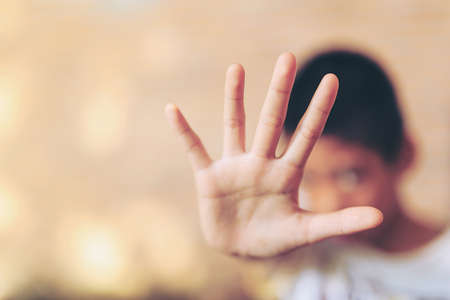 Children violence. boy, lad with her hand extended signaling to stop Children violence. boy, lad...