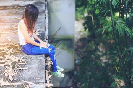 Teenager with depression sitting alone on abandoned buildingsの写真素材