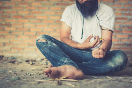 Drug addict young man with syringe in action, Drug abuse concept.,の写真素材