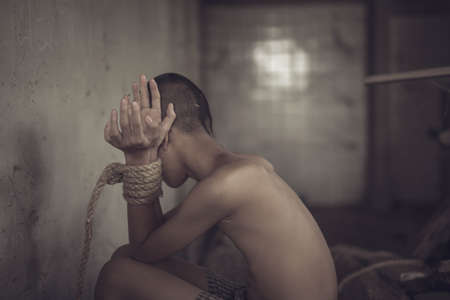 boy of a victim tied up with ropeの写真素材