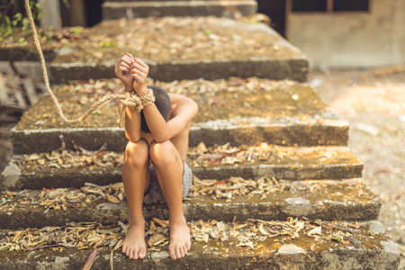 boy of a victim tied up with ropeの写真素材