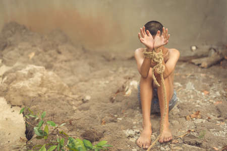 boy of a victim tied up with ropeの写真素材