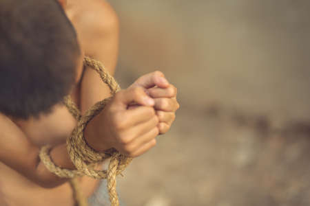 boy of a victim tied up with ropeの写真素材