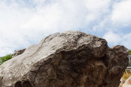 a pile of copper rocks piled up with blue sky and clouds of backgroundの写真素材