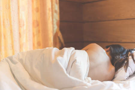 woman sit on a bed in a bedroom - concept photo of Sexual assaultの写真素材