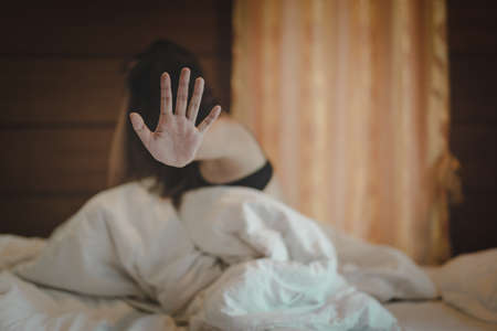 woman sit on a bed in a bedroom - concept photo of Sexual assaultの写真素材