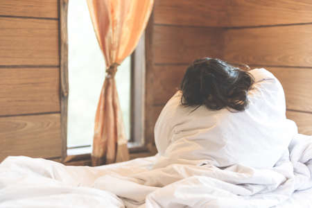 woman sit on a bed in a bedroom - concept photo of Sexual assault