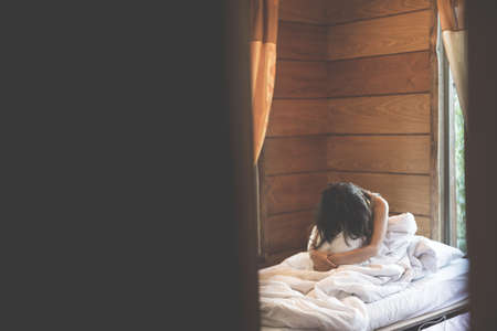 woman sit on a bed in a bedroom - concept photo of Sexual assaultの写真素材