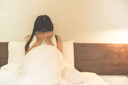 woman sit on a bed in a bedroom - concept photo of Sexual assaultの写真素材