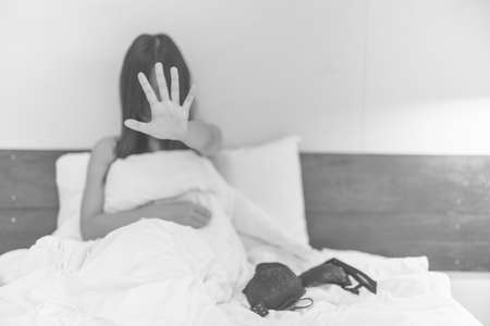 woman sit on a bed in a bedroom - concept photo of Sexual assaultの写真素材