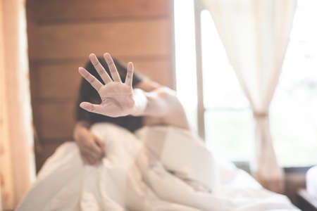 woman sit on a bed in a bedroom - concept photo of Sexual assault