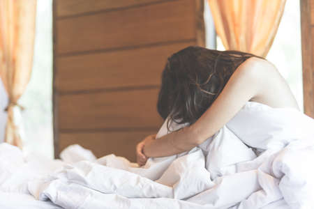 woman sit on a bed in a bedroom - concept photo of Sexual assaultの写真素材