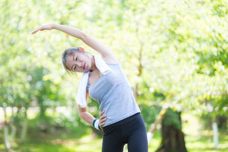 Beautiful fit young woman public park fitness stretching
