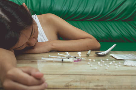 Drug addict young woman with syringe in action, Drug abuse concept.の写真素材