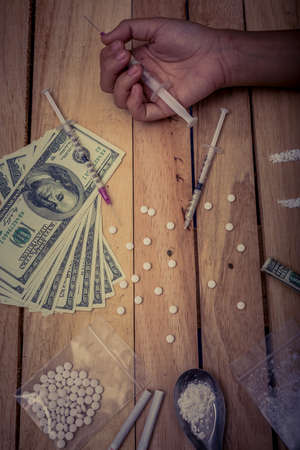 Drug addict young woman with syringe in action, Drug abuse concept.の写真素材