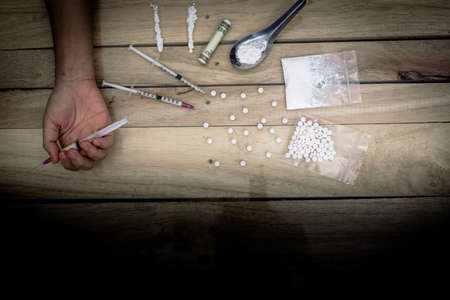 Drug addict young woman with syringe in action, Drug abuse concept.の写真素材