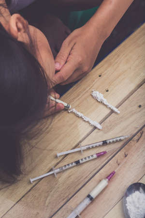 Drug addict young woman with syringe in action, Drug abuse concept.
