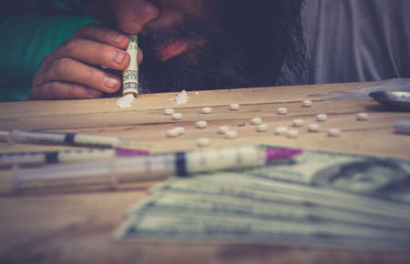 Drug addict young woman with syringe in action, Drug abuse concept.の写真素材