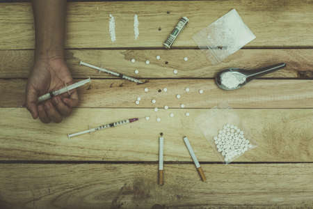 Drug addict young woman with syringe in action, Drug abuse concept.の写真素材