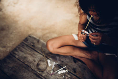 Drug addict young woman with syringe in action, Drug abuse concept.の写真素材