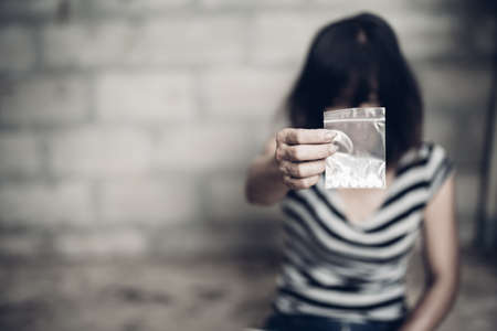 Drug addict young woman with syringe in action, Drug abuse concept.