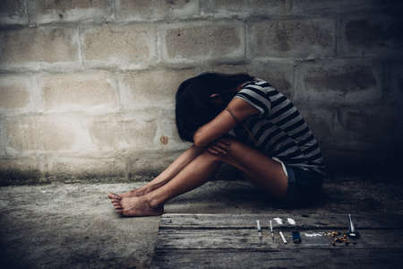 Drug addict young woman with syringe in action, Drug abuse concept.の写真素材